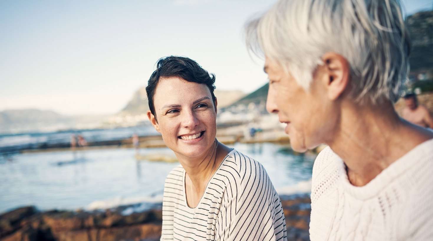 Zwei lächelnde Frauen vor einem See