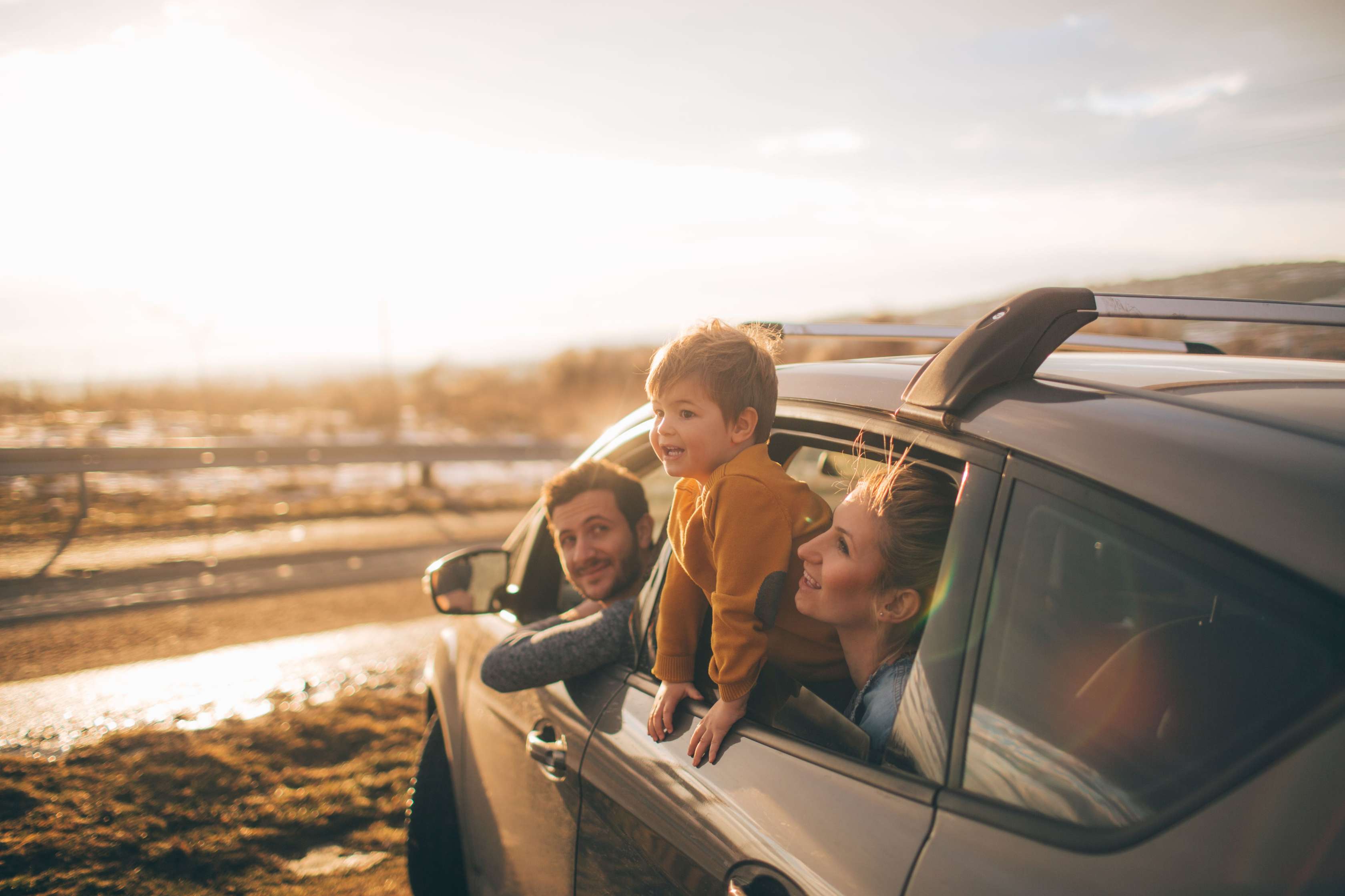 Familie sieht aus Fenster eines stehenden PKWs