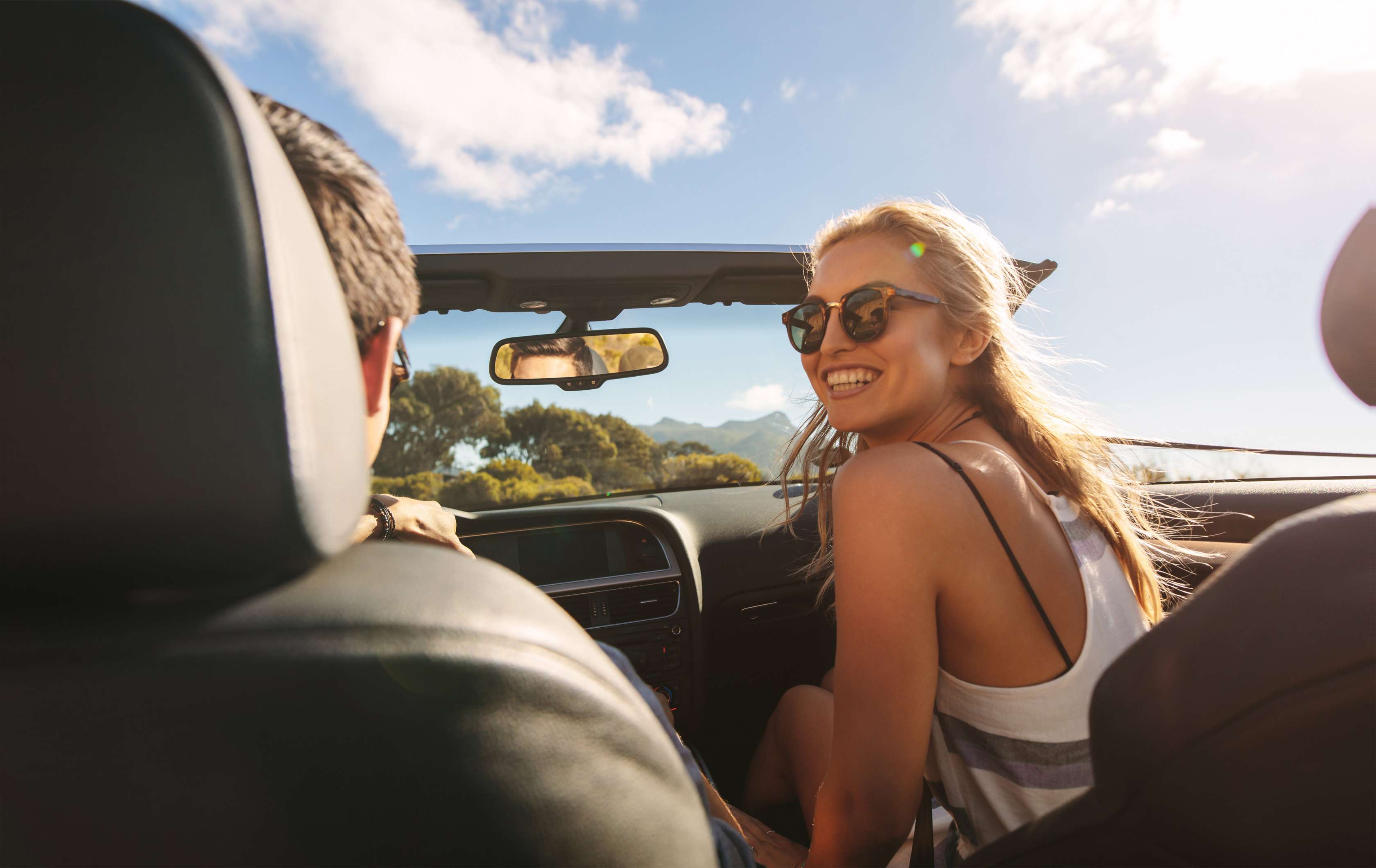 Pärchen sitzt in einem geöffneten Cabriolet
