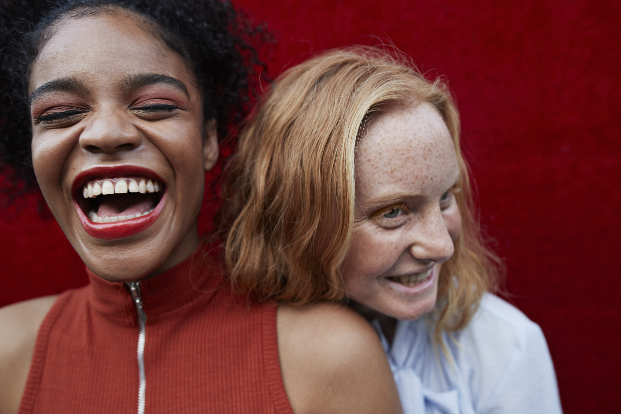 Frauen lehnen lachend aneinander