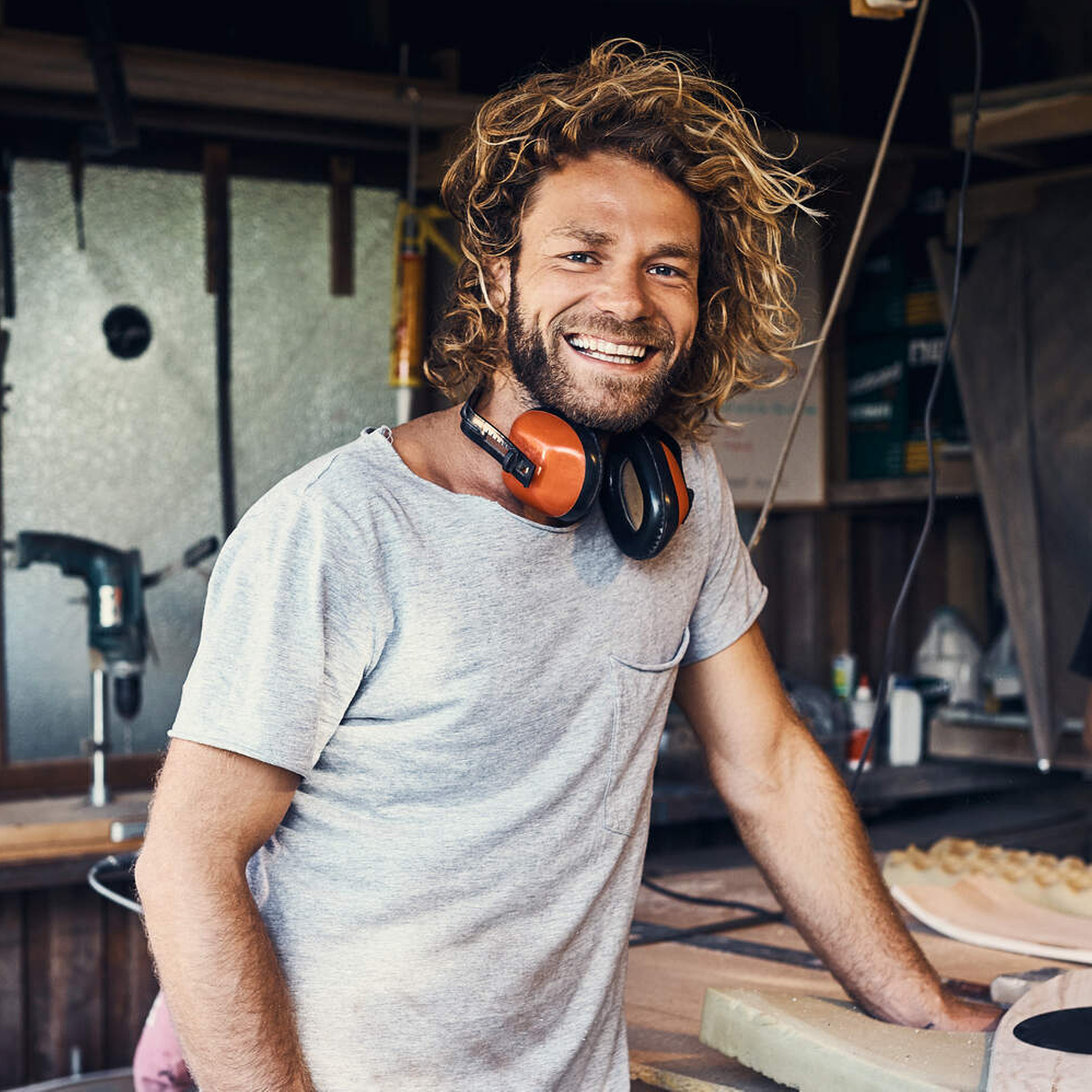 Porträt von zwei fröhlichen jungen Männern, die in ihrer Werkstatt an Skateboards arbeiten