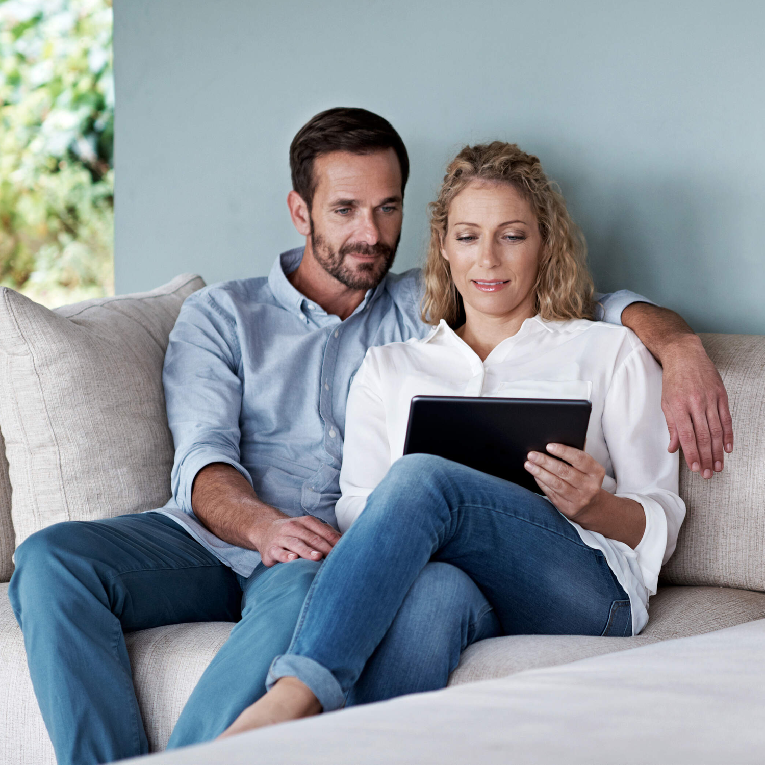 Ausgeschnittene Aufnahme eines Paares, das ein Tablet benutzt, während es sich auf dem Sofa entspannthttp://195.154.178.81/DATA/i_collage/pu/shoots/804607.jpg