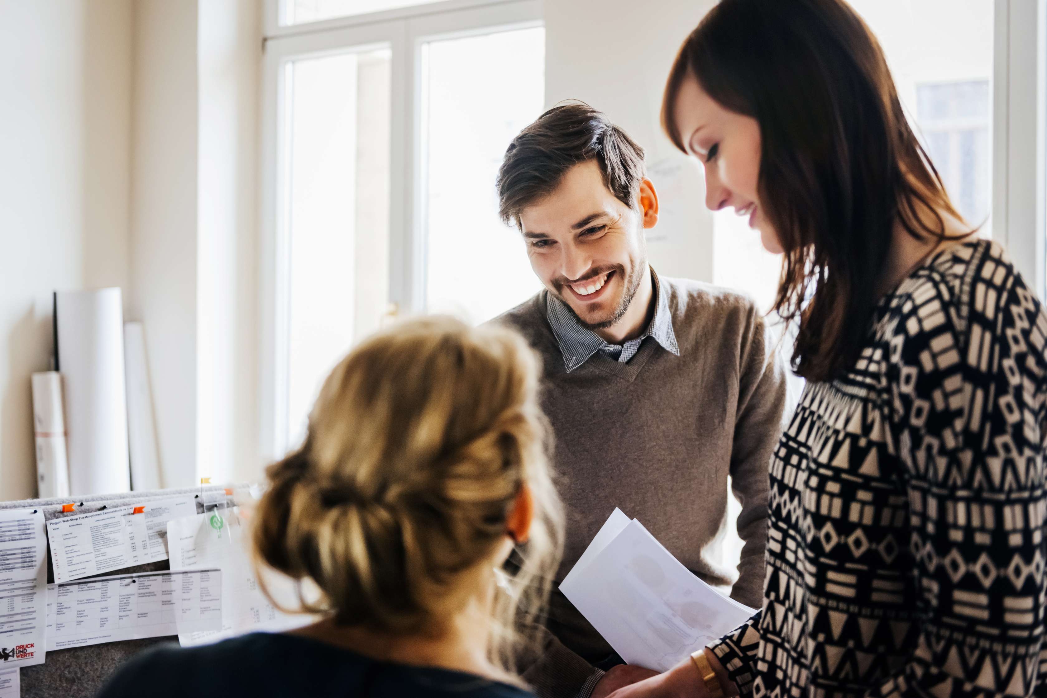 junger Mann und zwei junge Frauen sind im Büro und lächeln - Das Bild ist urheberrechtlich geschützt. Eine Nutzung ohne vorherige Einwilligung ist nicht gestattet. junger Mann und zwei junge Frauen sind im Büro und lächeln