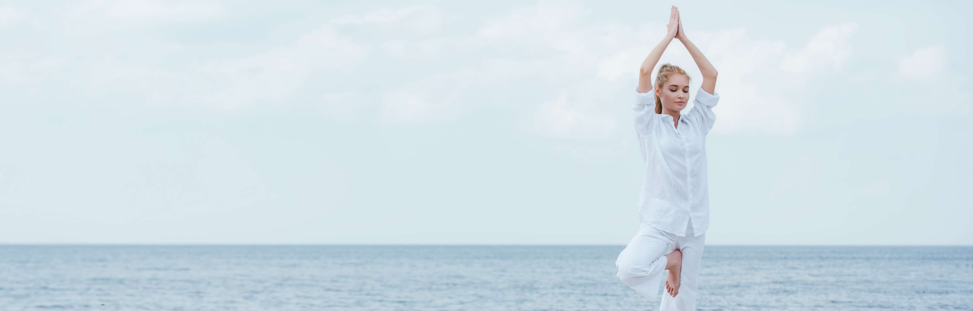 Frau in weiß am Strand in Yoga-Übing Frau in weiß am Strand in Yoga-Übing