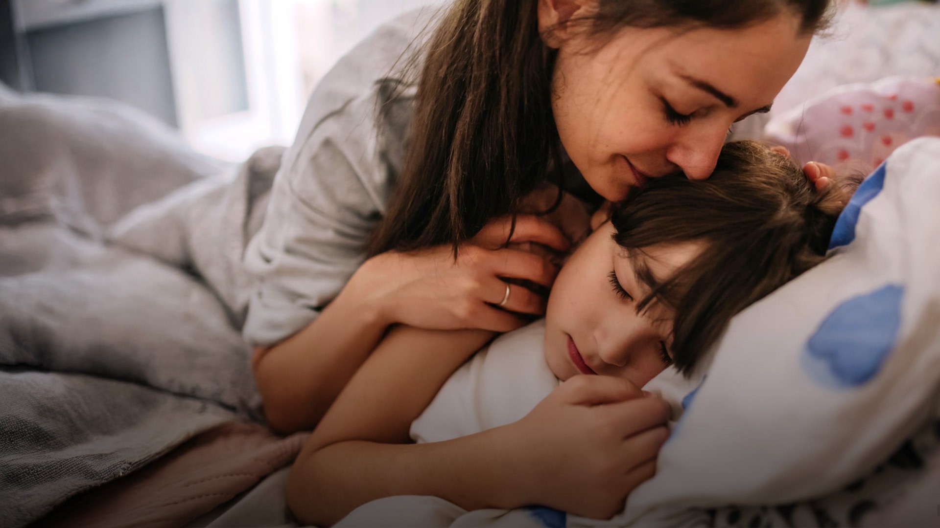 Mutter tollt gemeinsam mit ihren zwei Kindern auf der Couch