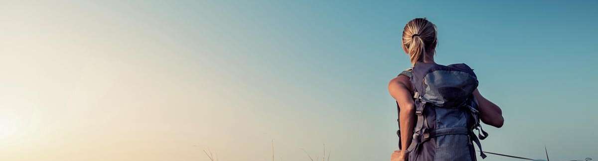 Junge Frau mit Rucksack beim Wandern