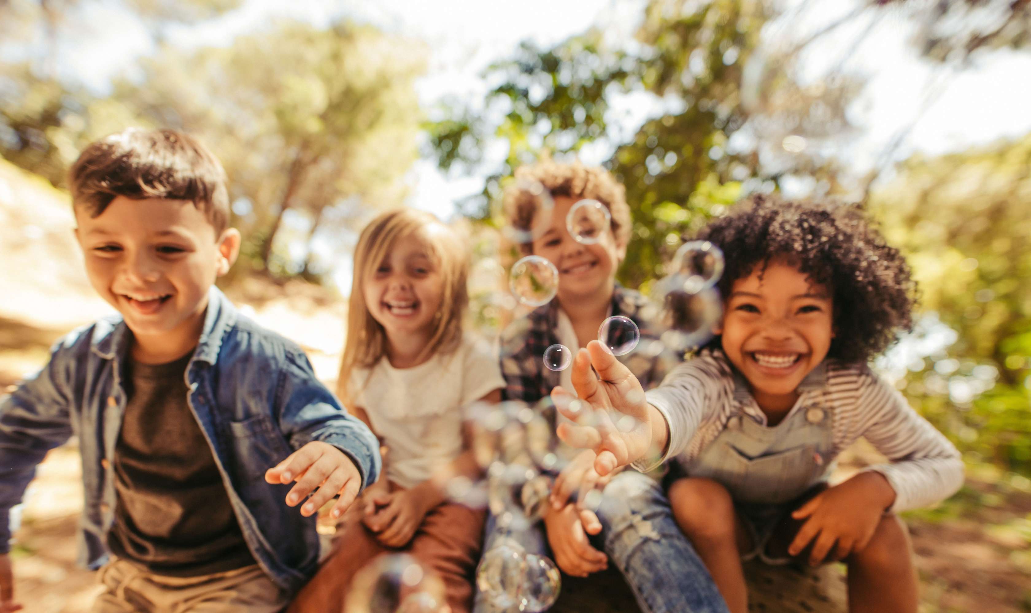 Kinder spielen mit Seifenblasen