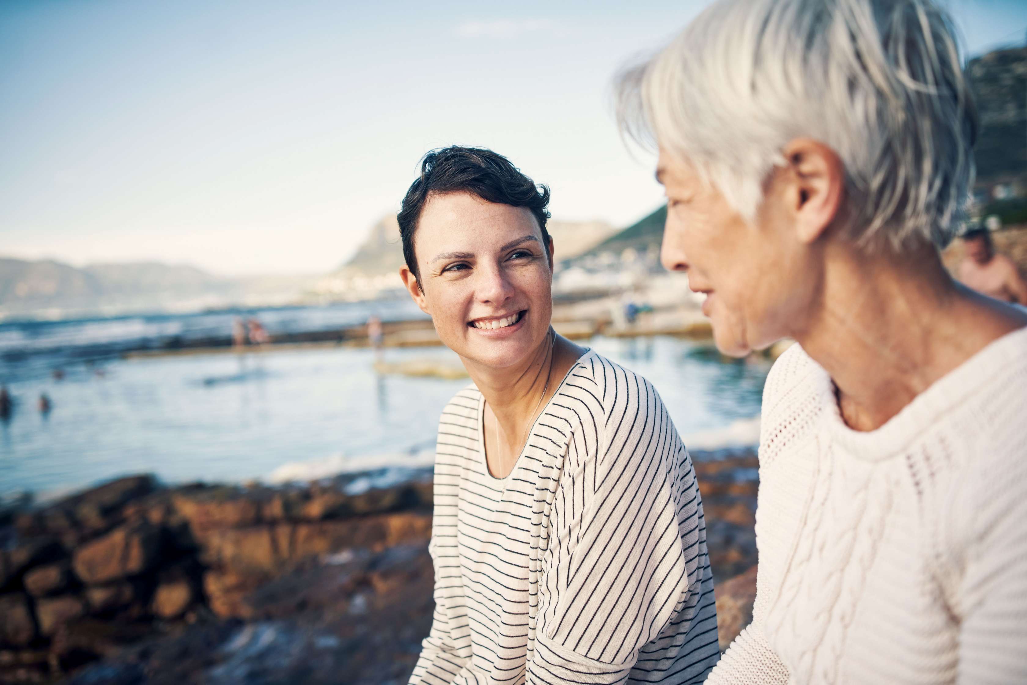 Junge und ältere Frau am Meer; schauen sich an Junge und ältere Frau am Meer; schauen sich an