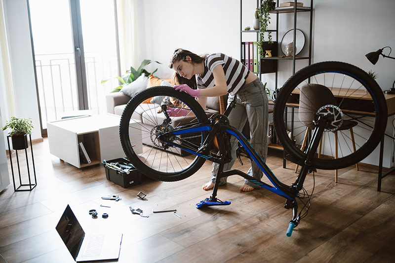 Frau repariert Fahrrad zuhause