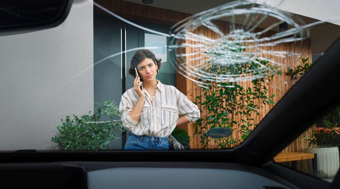 Frau meldet telefonisch Auto Glasschaden