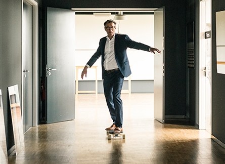Mann fährt mit Skateboard durch Büroräume