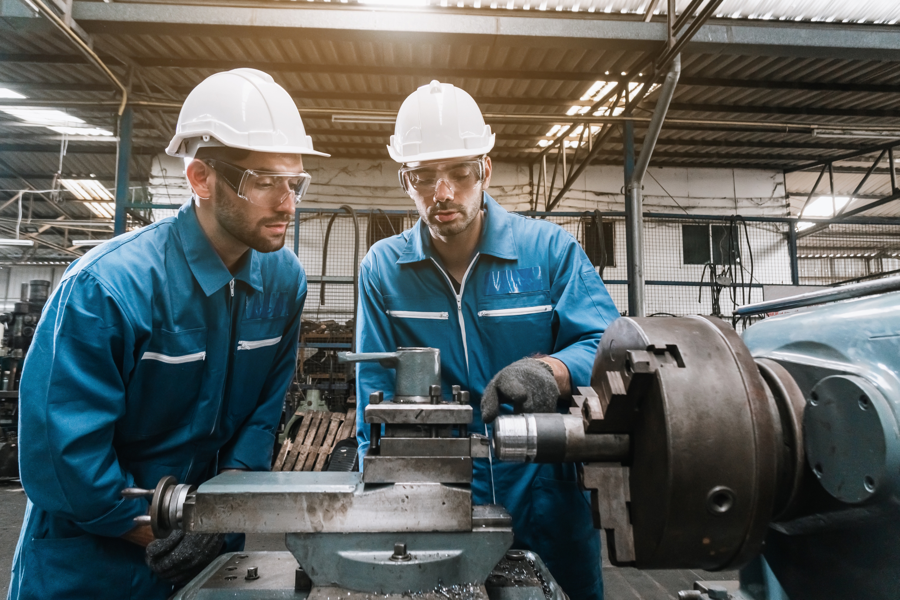 Zwei Arbeiter begutachten eine mechanische Verbindung