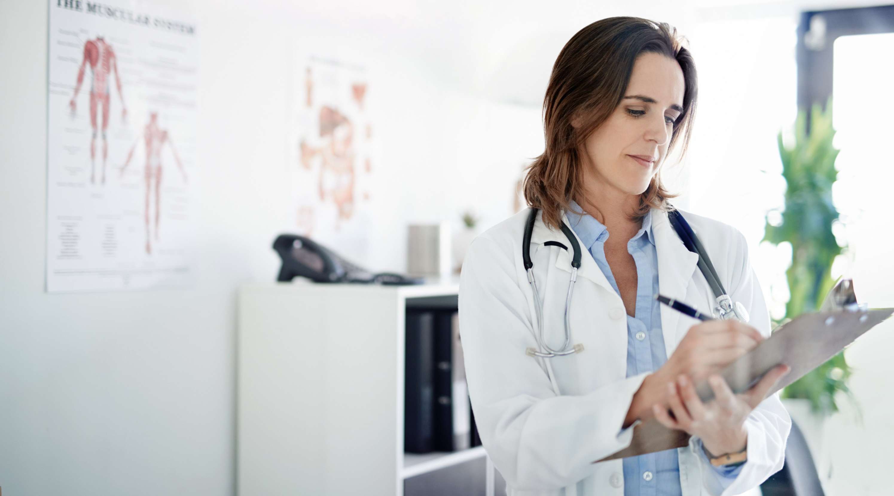 Ärztin notiert in einer Akte