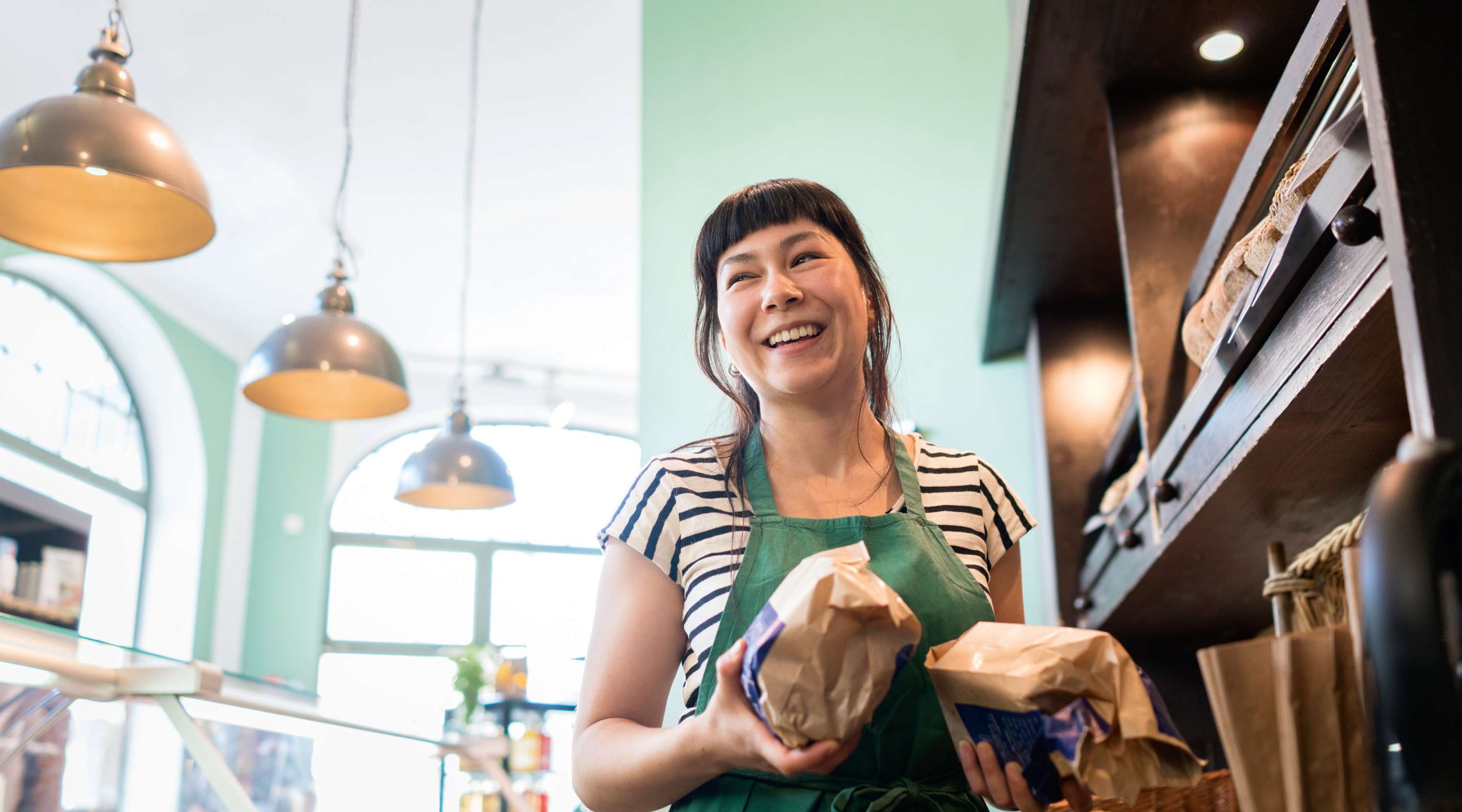 Lachende Verkäuferin mit Brot