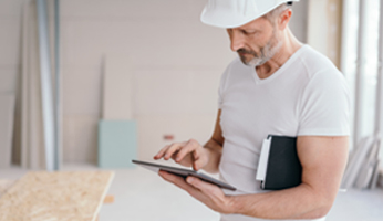 Handwerker mit Helm und Tablet
