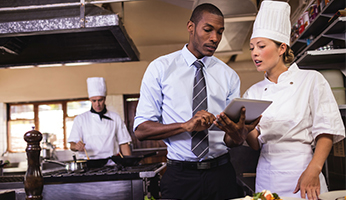 Mitarbeiter und Köchin in einer Küche