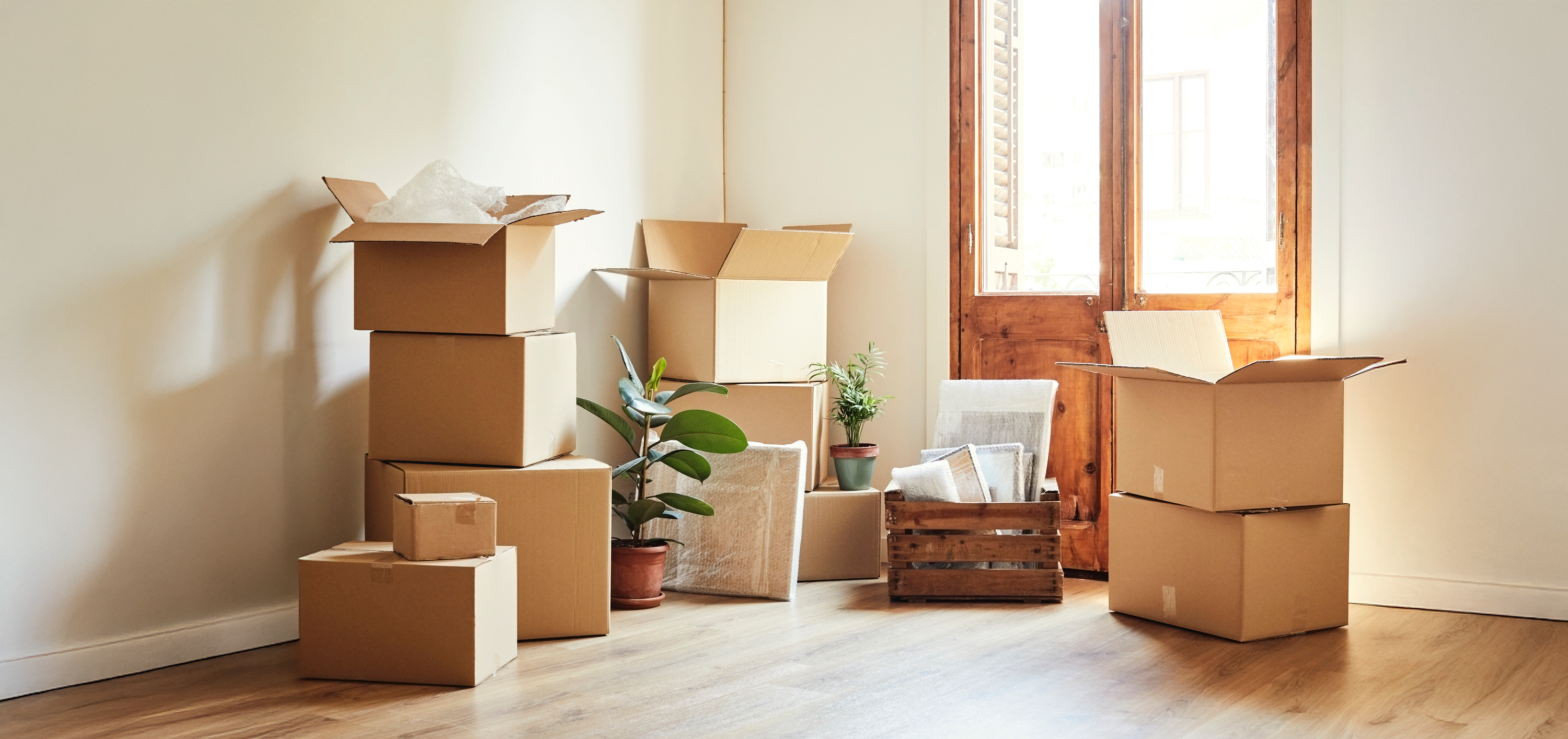 Gestapelte Umzugskartons stehen in einem Zimmer