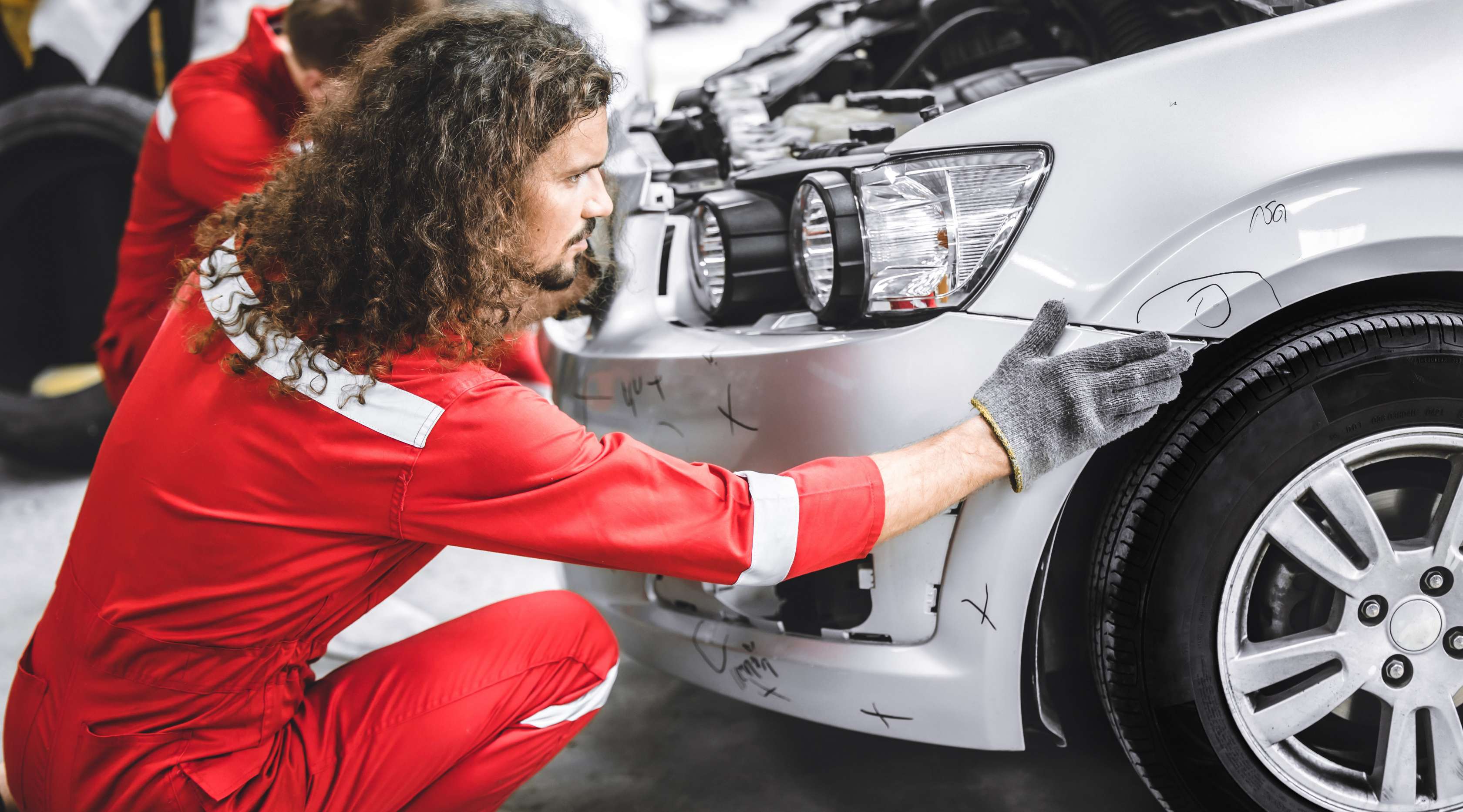 Arbeiter prüft Kotflügel eines PKWs