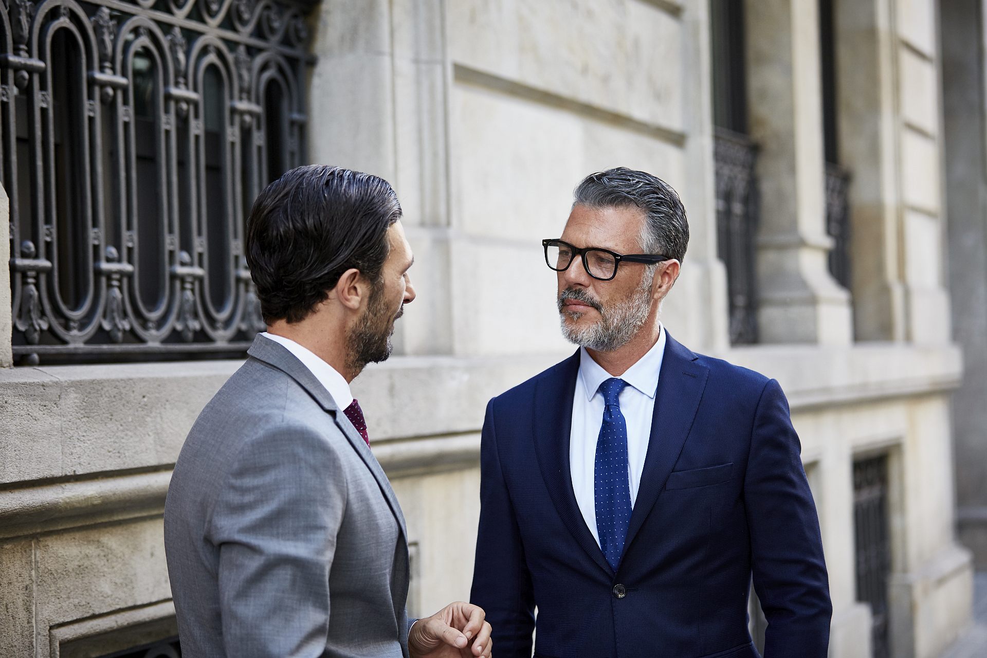 Key-Visual für Rechts- und wirtschaftsberatende Berufe: Zwei Männer im Anzug im Gespräch