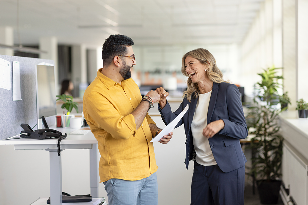 Zwei lachende Personen im Büro