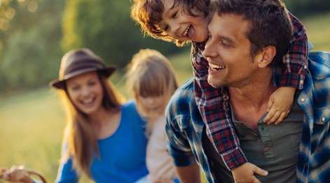 Familie macht Picknick auf Wiese