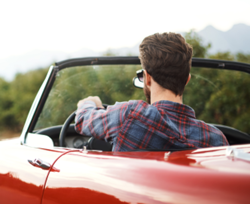 Mann in rotem Cabrio